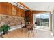 Bright sun room featuring wood accents, stone wall and a table set for four at 30651 Hollings Way, Golden, CO 80403