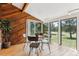 Bright sun room with wood paneled walls, tile flooring, and views of the backyard at 30651 Hollings Way, Golden, CO 80403