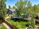 A spacious backyard with a lawn, shade trees, a play structure, a neighboring house, and a wood fence at 10765 Fremont Dr, Parker, CO 80134