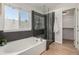 Modern bathroom featuring soaking tub, frameless shower, neutral tiling, and natural light at 10765 Fremont Dr, Parker, CO 80134