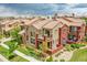 Aerial view of townhomes featuring tile roofs, stone accents, landscaping, and sidewalks at 9538 Pendio Ct, Highlands Ranch, CO 80126