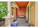 Inviting front porch featuring brickwork, metal bench, and colorful planters at 9538 Pendio Ct, Highlands Ranch, CO 80126