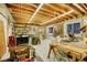 Spacious basement workshop with exposed ceiling, shelving, and bright lighting, perfect for DIY projects at 56920 E 42Nd Ct, Strasburg, CO 80136