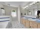 Bright bathroom with double sinks, wooden cabinets, and a large mirror over the vanity at 56920 E 42Nd Ct, Strasburg, CO 80136