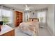 Cozy bedroom featuring a large bed and quilt, a bookcase, and windows at 56920 E 42Nd Ct, Strasburg, CO 80136