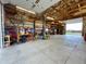 Garage with exposed timber beams, storage shelves, and a car lift at 56920 E 42Nd Ct, Strasburg, CO 80136
