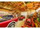 The garage has ample storage on wooden shelves and space for a variety of vehicles and equipment at 56920 E 42Nd Ct, Strasburg, CO 80136