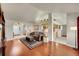 Bright living room with hardwood floors, neutral decor, and open layout to kitchen and entry at 56920 E 42Nd Ct, Strasburg, CO 80136