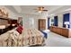 Serene main bedroom with tray ceiling, plush carpet, walk-in closet, and ensuite bathroom at 56920 E 42Nd Ct, Strasburg, CO 80136