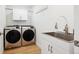 Bright laundry room with modern appliances and cabinets at 14800 Foothill Rd, Golden, CO 80401