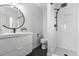 Modern bathroom with sleek white vanity, round mirror, and a walk-in shower at 2490 S Coors St, Lakewood, CO 80228