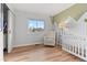 Bright Bedroom with hardwood floors, chair, crib, and a stylish mountain mural at 2490 S Coors St, Lakewood, CO 80228