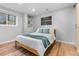 Bright bedroom featuring hardwood floors, neutral paint, natural light, and a full-sized bed with blue accents at 2490 S Coors St, Lakewood, CO 80228