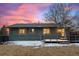 Back exterior featuring manicured lawn, deck, and the home under a colorful sunset at 2490 S Coors St, Lakewood, CO 80228