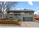 Charming two-story home featuring a modern garage door and appealing exterior paint, set against a blue sky at 2490 S Coors St, Lakewood, CO 80228