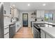 Modern kitchen featuring white cabinetry, stainless steel appliances, and an eat-in island with sleek countertops at 2490 S Coors St, Lakewood, CO 80228