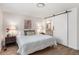 Comfortable bedroom featuring a barn door leading to the en-suite bathroom and two bedside tables at 5332 S Lisbon Way, Centennial, CO 80015