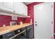 Stylish laundry room with butcher block countertop and overhead white cabinets at 5332 S Lisbon Way, Centennial, CO 80015