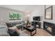 Comfortable living room with large window, fireplace, and plush seating, creating a relaxing atmosphere at 5332 S Lisbon Way, Centennial, CO 80015