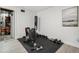 Personal home gym featuring various workout equipment including weights and a bench at 6376 E Mississippi Ave, Denver, CO 80224