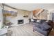 Spacious living room features a brick fireplace, modern furnishings, and a view of the staircase at 6376 E Mississippi Ave, Denver, CO 80224