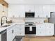 This modern kitchen features white shaker cabinets, stainless steel appliances, and light countertops at 7205 S Gaylord St # G, Centennial, CO 80122