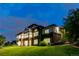 Stately two-story home with stone and stucco facade, multiple decks, and lush green lawn at twilight at 1525 W 141St Way, Westminster, CO 80023