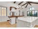 Bright kitchen with two islands, farm sink, wood floors, and custom hood at 1525 W 141St Way, Westminster, CO 80023