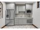 Modern kitchenette featuring stainless steel appliances, gray cabinetry, and a marble backsplash, perfect for a convenient food prep area at 1525 W 141St Way, Westminster, CO 80023