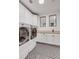 Bright laundry room with high-efficiency washer and dryer, ample cabinet space, and stylish patterned flooring for an efficient space at 1525 W 141St Way, Westminster, CO 80023