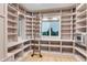 Organized pantry with custom shelving, a sliding ladder for easy access, a window for natural light, and built-in storage solutions at 1525 W 141St Way, Westminster, CO 80023