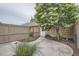 Fenced backyard with a concrete patio, lush plants and mature tree for privacy and shade at 222 S Monroe St, Denver, CO 80209
