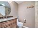 Cozy bathroom with a warm vanity, round mirror and step-in shower with earth tone tiles at 222 S Monroe St, Denver, CO 80209