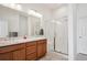 Bright bathroom features double sinks, a walk-in shower with glass door, and white tile at 22046 E Allenspark Pl, Aurora, CO 80016