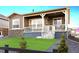 Beautiful home with stone accents and a covered patio, complemented by an artificial lawn at 22046 E Allenspark Pl, Aurora, CO 80016