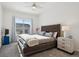 Inviting main bedroom with a ceiling fan, tufted headboard, and a window offering plenty of natural light at 22046 E Allenspark Pl, Aurora, CO 80016