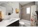 Functional bathroom with a combination tub and shower, stylish vanity, and a large circular mirror at 2957 Osceola St, Denver, CO 80212