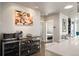 Open dining area with a wine rack, beverage fridge, modern artwork and hardwood floors at 2957 Osceola St, Denver, CO 80212