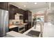 Modern kitchen with dark cabinetry, stainless steel appliances, and white countertops with a view into dining area at 2957 Osceola St, Denver, CO 80212