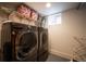 Efficient laundry room with front-loading washer and dryer set and shelving at 2957 Osceola St, Denver, CO 80212