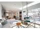 Open concept living room featuring an industrial-style glass door, hardwood floors and lots of natural light at 2957 Osceola St, Denver, CO 80212