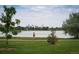 Scenic view of a runner on a paved path in a park with lush greenery and lake in background at 2957 Osceola St, Denver, CO 80212