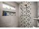 Elegant shower features stylish patterned tile and a window with greenery and natural light at 2957 Osceola St, Denver, CO 80212