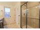 Well-lit bathroom featuring a glass shower enclosure, neutral walls, tile flooring, and storage at 5316 Stuart St, Denver, CO 80212