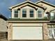 Two-story home featuring a two-car garage with brick accents at 5316 Stuart St, Denver, CO 80212