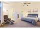 Comfortable main bedroom featuring a plush chair, ensuite bath, ceiling fan, and decoratively framed prints at 5316 Stuart St, Denver, CO 80212