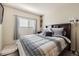 Comfortable bedroom featuring a stylish comforter, side table, and a window with light-blocking blinds for a serene atmosphere at 11009 Gaylord St, Northglenn, CO 80233