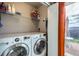Efficient laundry room equipped with a washer, dryer, storage shelves, and access to an outdoor patio at 11009 Gaylord St, Northglenn, CO 80233
