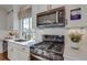 Modern kitchen features stainless steel appliances, white cabinets, quartz countertop, and a gas range at 1218 Sugarloaf Ln, Erie, CO 80516