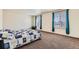 Bright bedroom with plush carpeting, large windows, and blue curtains at 2417 Mountain Sky Dr, Fort Lupton, CO 80621